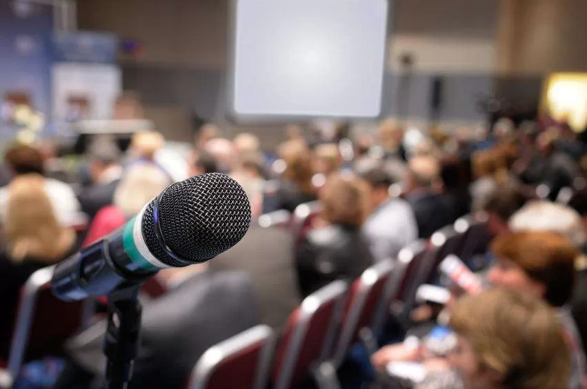 Conference microphone positioned before a seated audience