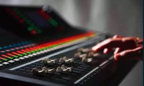 Audio engineer operating a professional sound mixing console